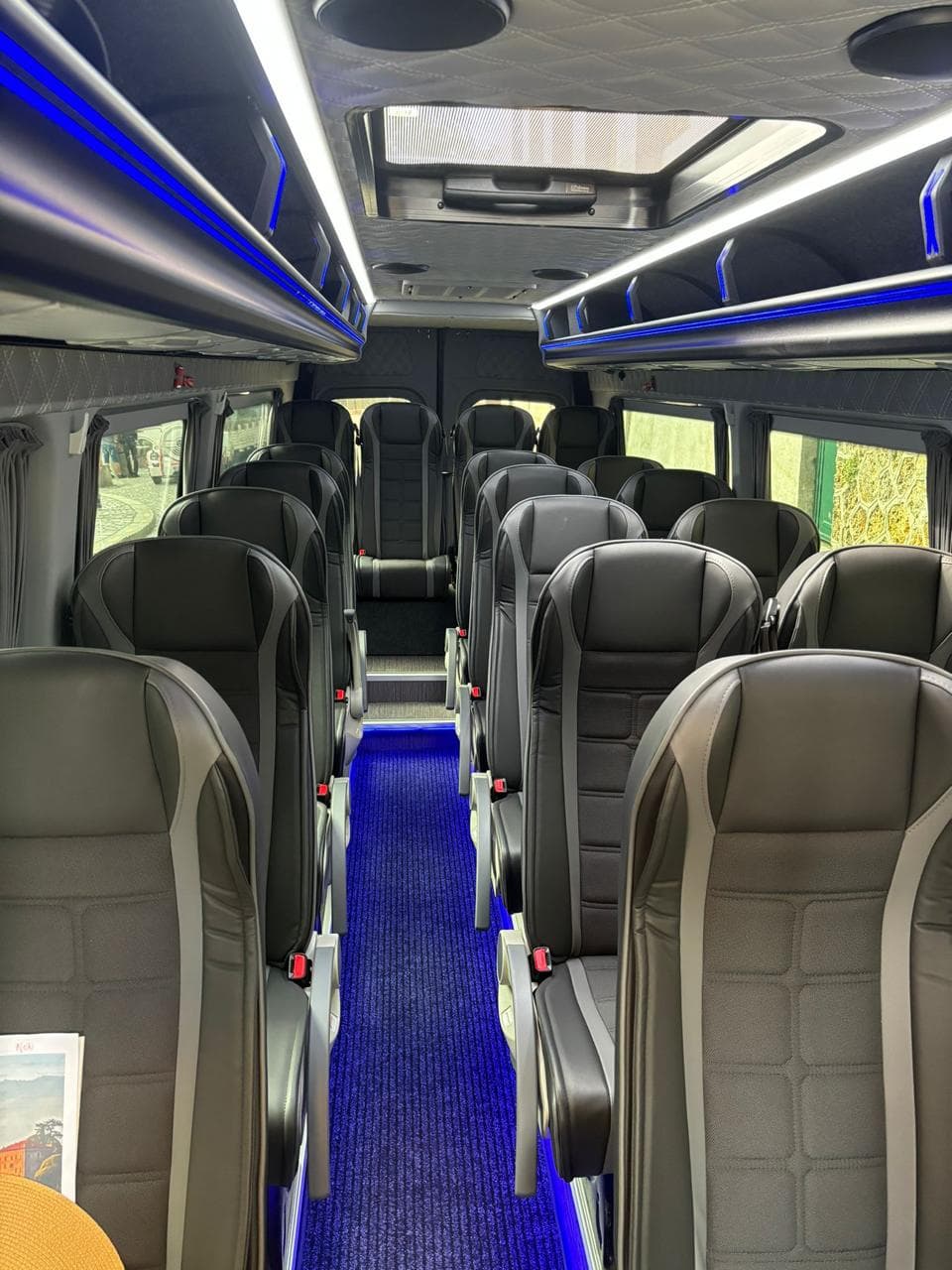 Intérieur d'un minibus Mercedes Sprinter : rangées de sièges et couloir central