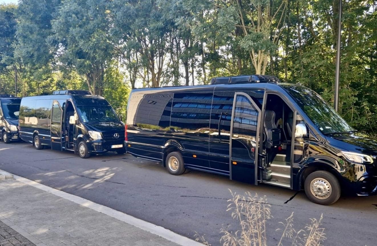 Deux minibus Mercedes Sprinter noirs alignés, portes ouvertes